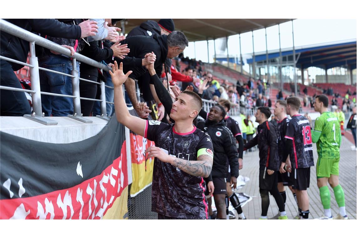 1. Göppinger SV fährt Big Points im Kampf gegen den Abstieg ein GSV-Kapitän Filip Milisic und sein Team feiern mit den mitgereisten Fans den 2:0-Auswärtssieg in Kassel.
Foto: IMAGO/Roland Sippel - Eibner-Pressefoto