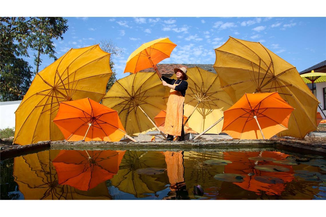 Bilder des Tages Gut beschirmt: Eine Arbeiterin lüftet Regenschirme aus Wachstuch im Dorf Gufeng im Kreis Jingxian in der ostchinesischen Provinz Anhui. Der Regenschirm aus geöltem Stoff und Bambusgestell wird immer noch traditionell von chinesischen Kunsthandwerkern hergestellt.