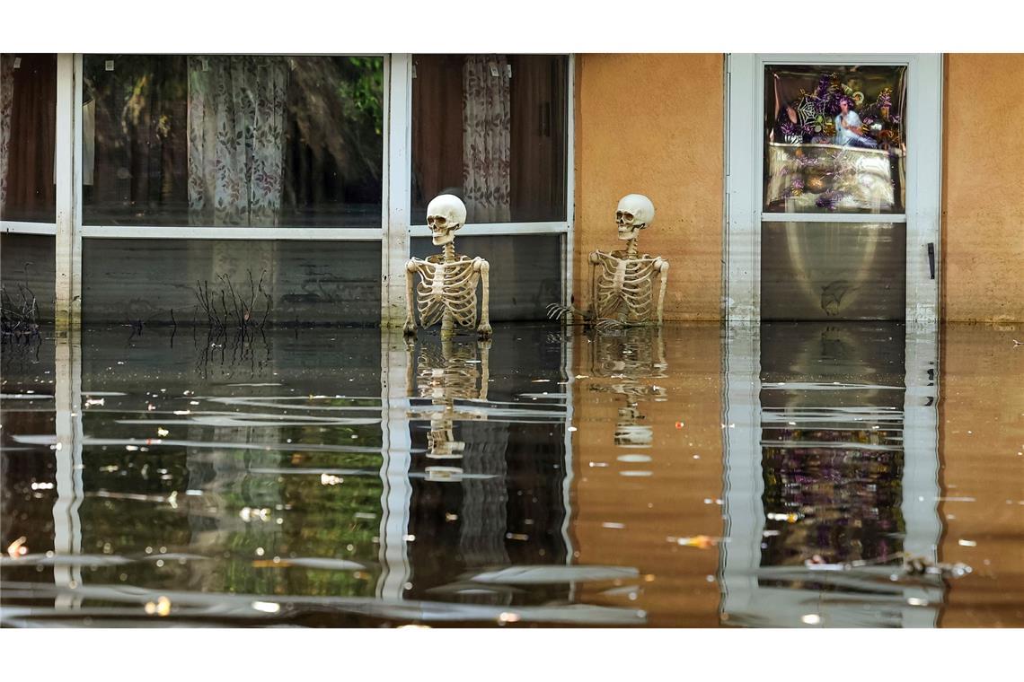 Bilder des Tages Halloween im Hochwasser: Zwei Deko-Skelette stehen bei Überschwemmungen nach Hurrikan Milton im US-Bundesstaat Florida bis über die knochigen Hüften im Wasser.