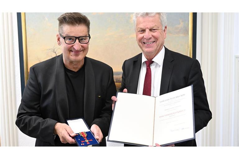 Hartmut Engler (links) und der Oberbürgermeister von Bietigheim-Bissingen, Jürgen Kessing mit dem Bundesverdienstkreuz und der dazugehörigen Urkunde.