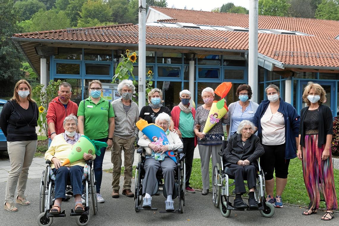 Heimleiterin Alexandra Zieffle (Zweite von rechts), das Betreuungsteam und einige Senioren treffen vor der Murrhardter Festhalle Martina Mayer, Rektorin der Walterichschule (rechts), und Andrea Erkert von der Hörschbachschule (links). Sie haben drei Schultüten für die Erstklässler dabei, vollgepackt mit Herzenswünschen. Foto: J. Fiedler (1)/privat (2)