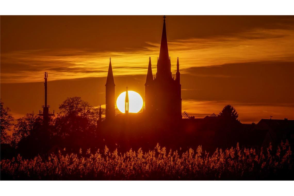 Hinter der Heilig-Geist-Kirche auf der Insel Werder geht die Sonne unter.
