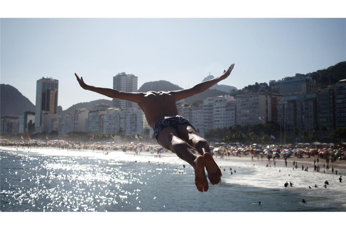 Bilder des Tages Hitzewelle in Rio de Janeiro: Ein Mann springt ins Meer am Strand Leme.