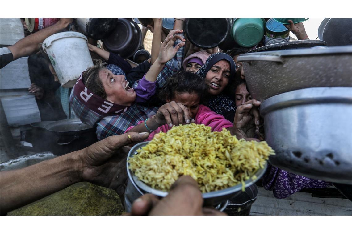 Bilder des Tages Hoffen auf Essen - Vertriebene Palästinenser stehen dicht gedrängt an, um Mahlzeiten von einer Wohlfahrtsorganisation zu bekommen.