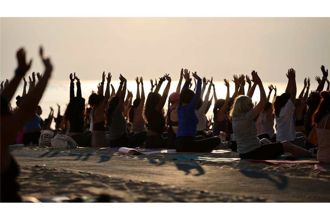 Hunderte Menschen nehmen an einer öffentlichen Yoga-Stunde am frühen Morgen am „Oak Street Beach“ am Lake Michigan teil.