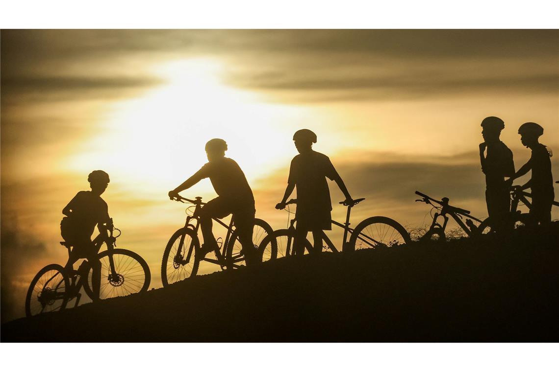 I want to ride my bicycle. Radfahrer machen eine Pause im Licht der Abendsonne auf den Philippinen.