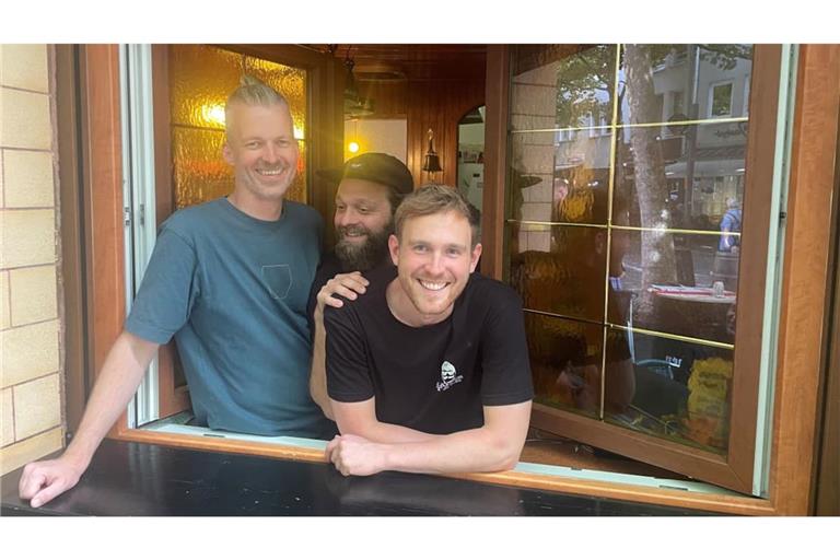 Idealisten gesucht: Daniel Sieben, Niklas Schmedding und Niklas Fiebach (l-r) schauen aus einem Fenster der Mainzer Kneipe „Zum Bierstübchen“, die sie 2024 übernommen haben.