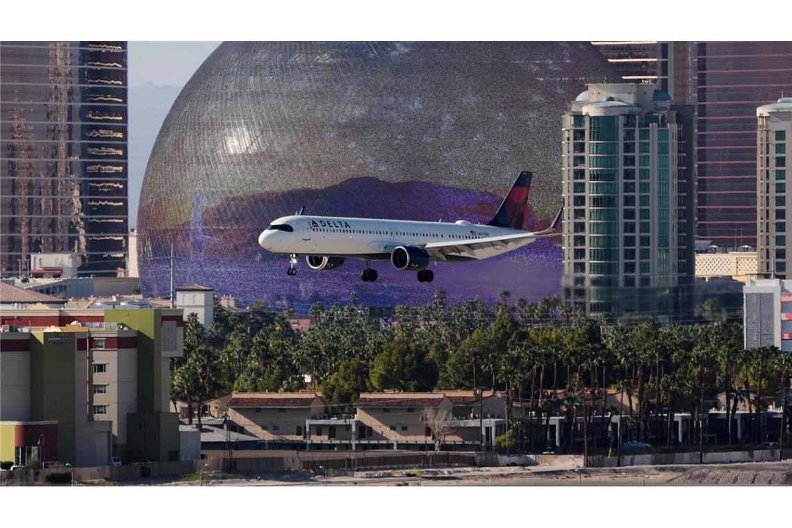 Im Anflug: Ein Flugzeug landet auf dem Harry Reid International Airport von Las Vegas. Im Hintergrund ist die „Sphere at The Venetian Resort“ zu sehen, eine riesige Konzerthalle und Event-Arena in Kuppelform.