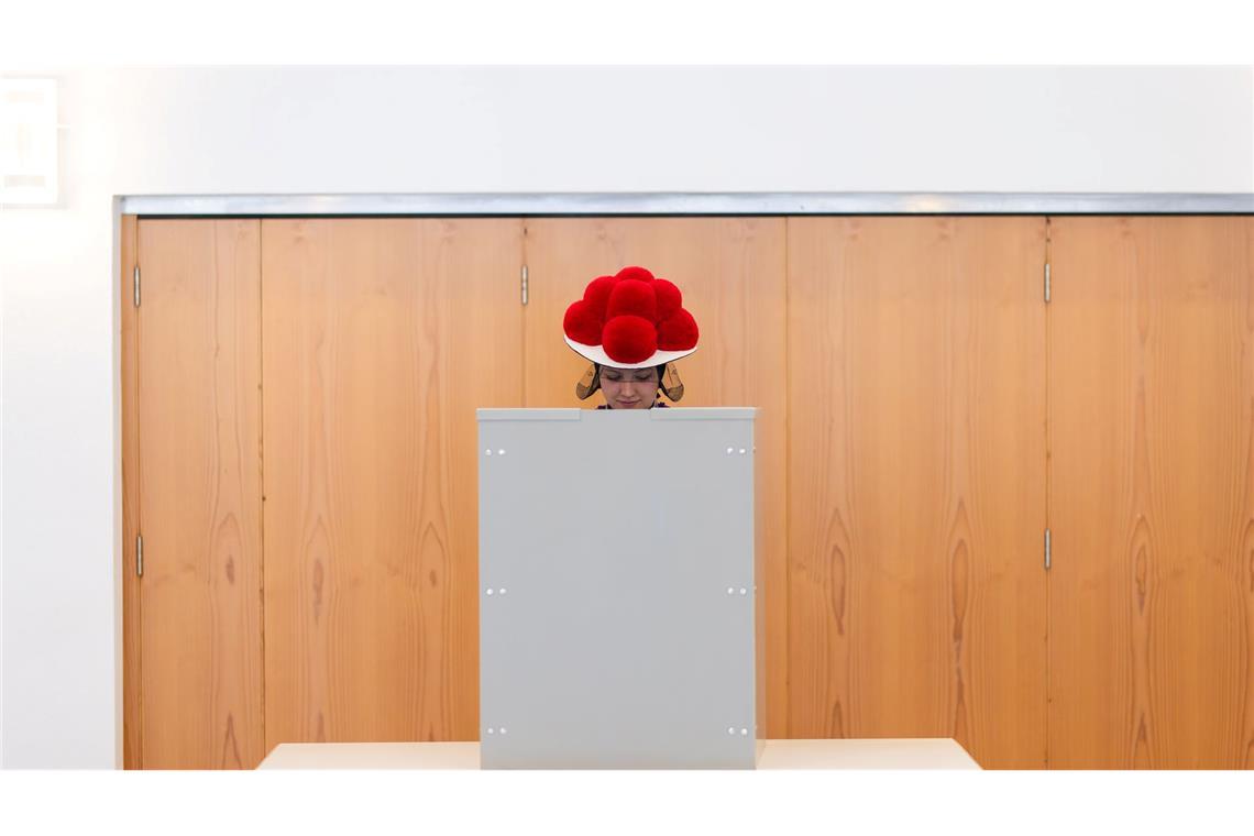 Bilder des Tages Im Bollenhut da wält's sich gut: Eine junge Frau steht in traditioneller Schwarzwälder Tracht mit Bollenhut in einer Wahlkabine in Gutach im Schwarzwald.