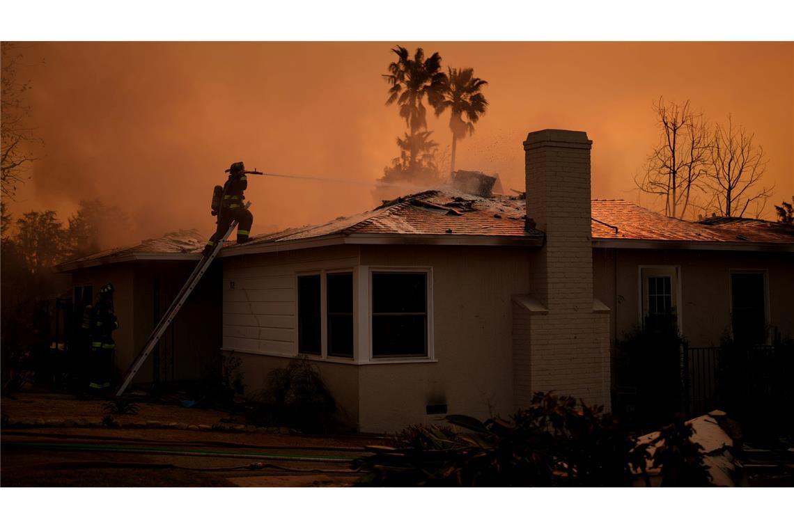 Brände in den USA: Kurze Entspannung, weiterhin große Gefahr Im Dauereinsatz: Ein Feuerwehrmann versucht, ein Wohnhaus vor den Flammen des "Eaton Fire" zu bewahren.