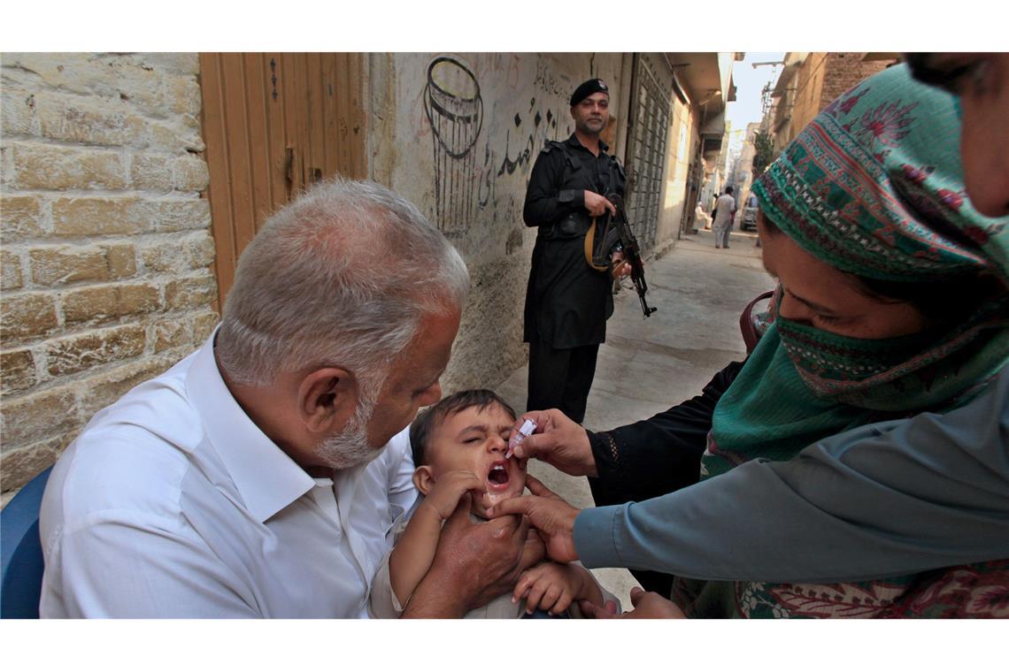 Pakistans schwieriger Kampf gegen die Kinderlähmung Impf-Teams in Pakistan werden von bewaffneten Männern bewacht, weil sie oft Ziel von Anschlägen sind. (Archivbild)