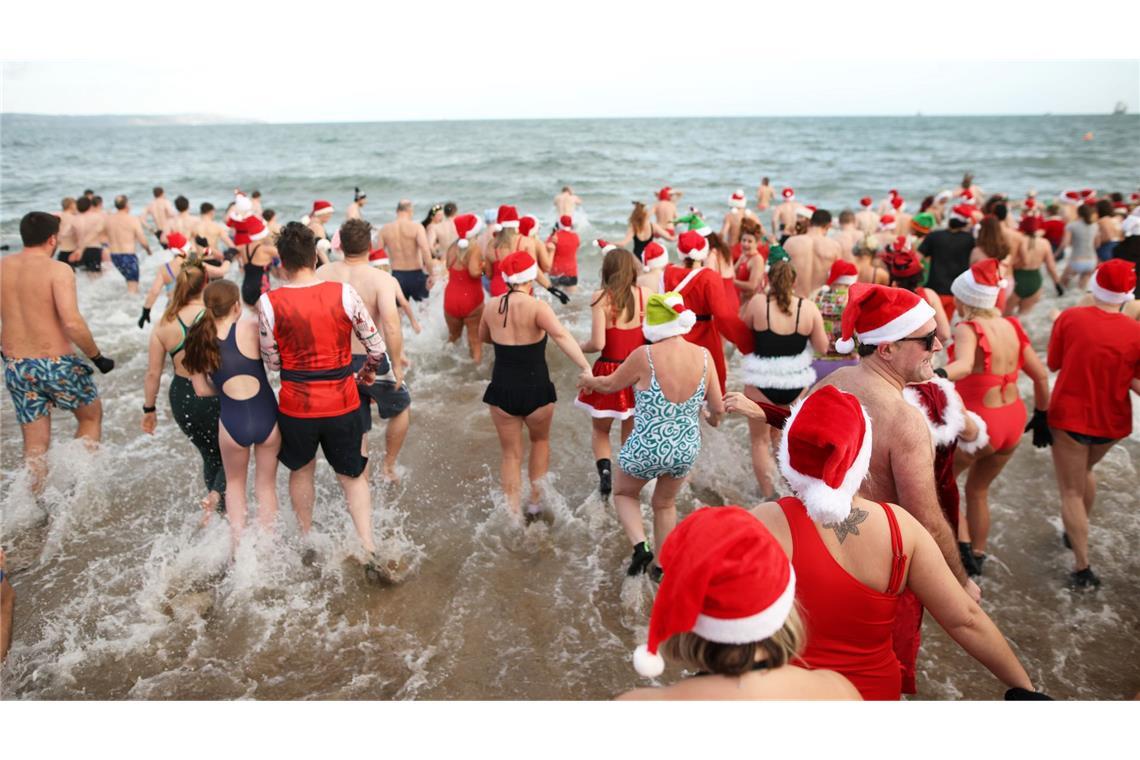 In der Helen's Bay in Nordirland schwimmen Menschen an Heiligabend im kalten Wasser des Belfast Lough, um Geld für Dementia NI und Air Ambulance NI zu sammeln.