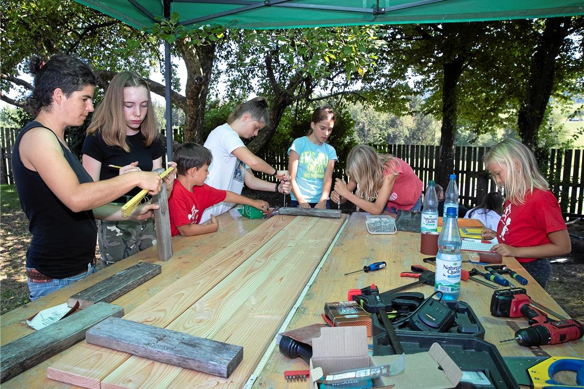 Ferien mit Buddelglück und Apfelbaum In der Holzwerkstatt wird schwer getüftelt. Das Projekt: Gemeinsam einen Sandkasten fürs Freizeitheim bauen und installieren. Veronika Ziegler (links) leitet die Kleingruppe an. Sie unterstützt die Freizeit außer der Reihe als Schreinerin. Foto: J. Fiedler