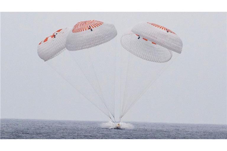 In diesem von der Nasa via AP zur Verfügung gestellten Bild gleitet die SpaceX-Kapsel mit vier Astronauten an Bord am Samstag vor der südkalifornischen Küste an Fallschirmen in den Pazifik.