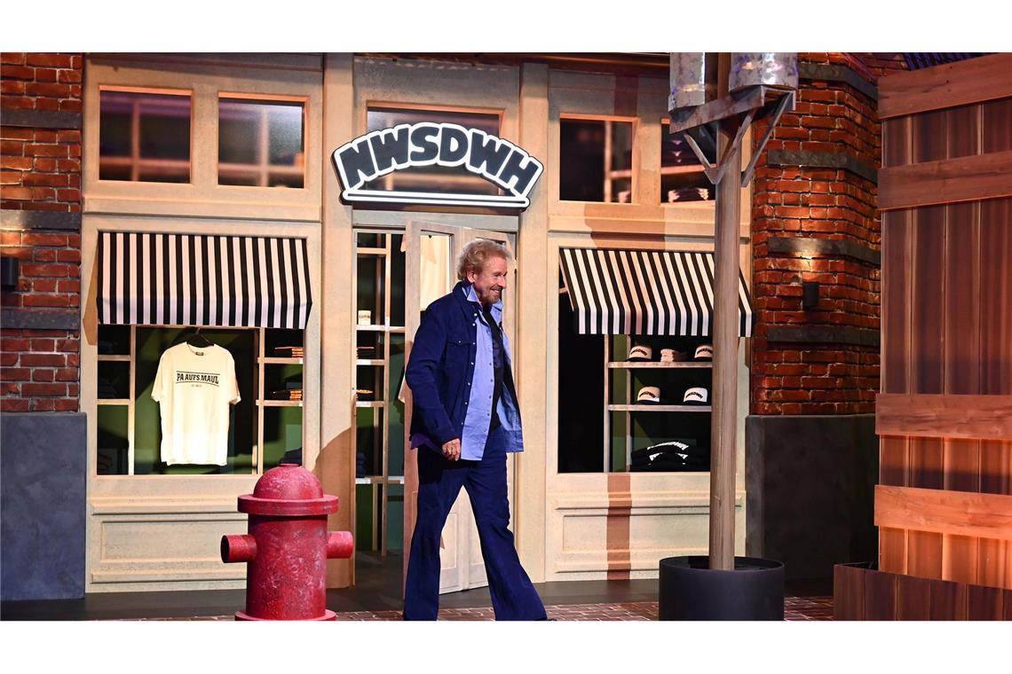 Thomas Gottschalk zu Stefan Raab: Du hast mehr Zähne als ich In Schlaghosen kommt Thomas Gottschalk durch eine Tür, über der NWSDWH steht. Er ist Gast in der RTL+-Streaming-Show "Du gewinnst hier nicht die Million bei Stefan Raab"