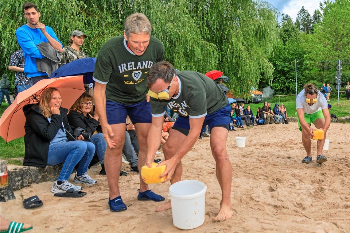 Wasserspiele beim Fornsbacher Sommernachtsfest In Teamarbeit müssen die Teilnehmer des Waldsee-Triathlons versuchen, Wasser mithilfe eines Schwamms von einem Eimer in den anderen zu transportieren. Fotos: Stefan Bossow