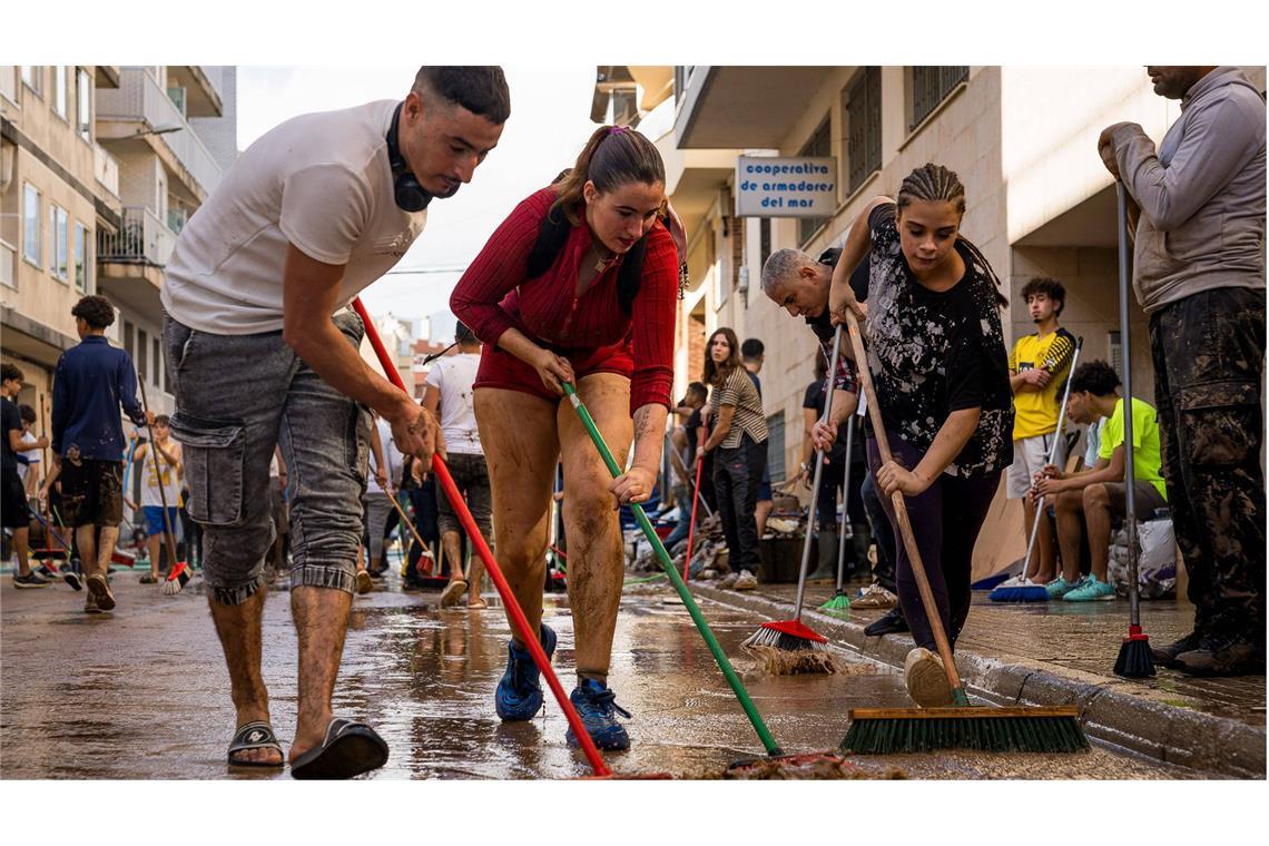 Déjà-vu in Valencia: Die Stadt wird wieder zur Schlammpiste In Valencia packen Freiwillige gemeinsam an und säubern die Straßen per Besen vom Schlamm.