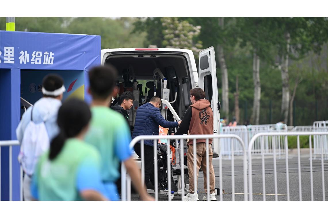Chinesische Roboter laufen Halbmarathon gegen Menschen Ingenieure durften entlang der Rennstrecke bei den Robotern nachjustieren.
