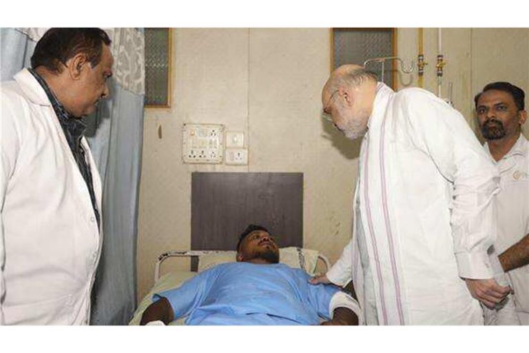 Innenminister Amit Shah bei einem Treffen mit dem einzigen Überlebenden des  Flugzeugabsturzes, dem 40-jährigen Vishwash Kumar Ramesh.