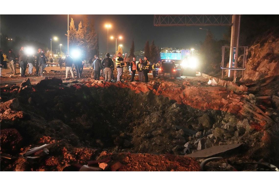Israelische Sicherheitskräfte inspizieren eine beschädigte Straße, nachdem eine aus dem Iran abgefeuerte Rakete in Jerusalem eingeschlagen ist.