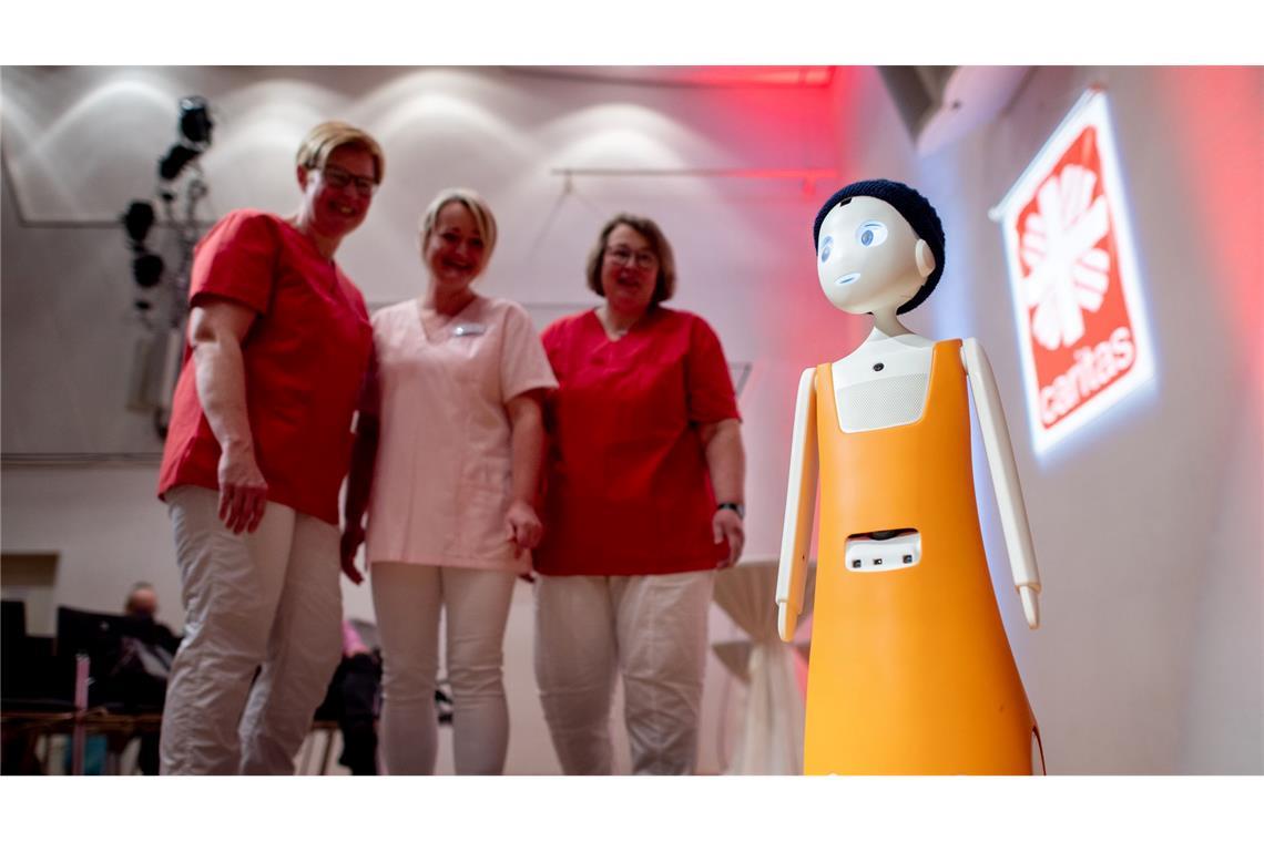 Bilder des Tages Ist das die neue Kollegin? Pflegekräfte sprechen beim Tag der Altenpflege in der Stadthalle von Cloppenburg in Niedersachsen mit dem Pflegeroboter „Navel“.