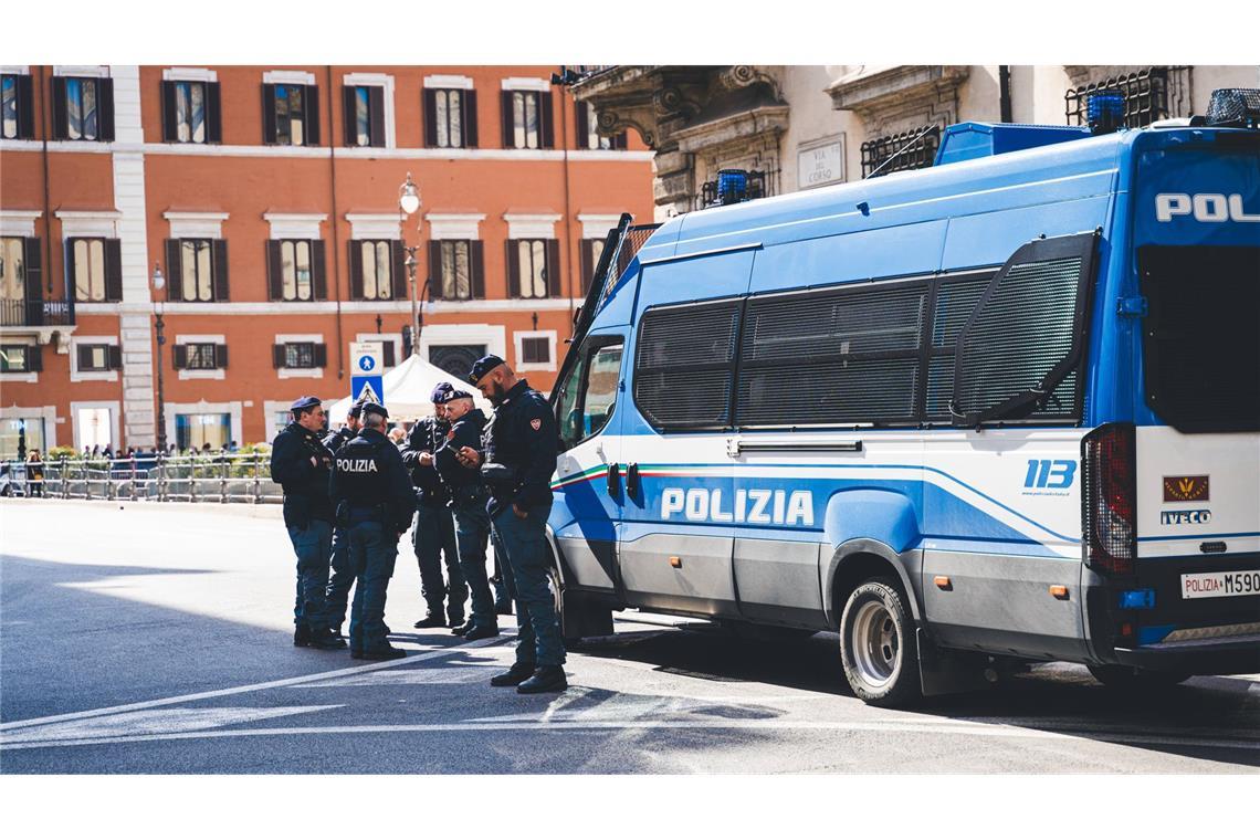 Italienische Polizisten vor einem Einsatzfahrzeug. (Symbolfoto)