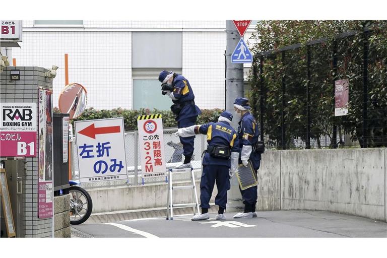Japanische Polizeiermittler arbeiten in der Nähe des Tatorts nachdem eine Frau in Tokio während eines Live-Streams auf offener Straße niedergestochen wurde