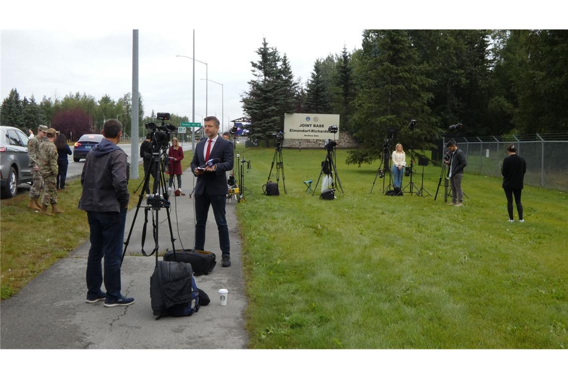 Journalisten stehen am Militärstützpunkt, auf dem das Treffen zwischen Putin und Trump voraussichtlich stattfindet.