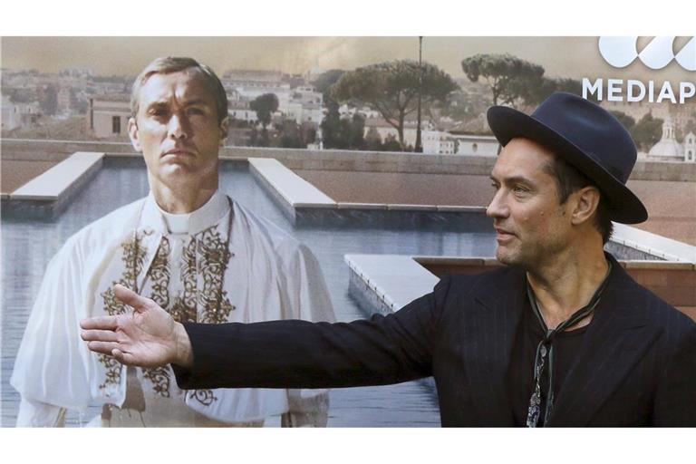 Jude Law vor einem Plakat mit sich als Papst Pius XIII. in der Serie "The Young Pope". (Archivbild)