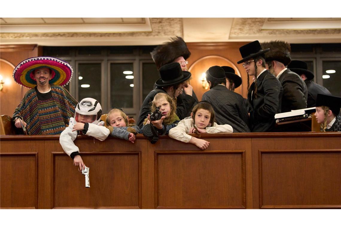Bilder des Tages Jüdische ultraorthodoxe Männer und Kinder, von denen einige Kostüme tragen, halten sich in einer Synagoge in Jerusalem im Rahmen des Purimfestes auf.
