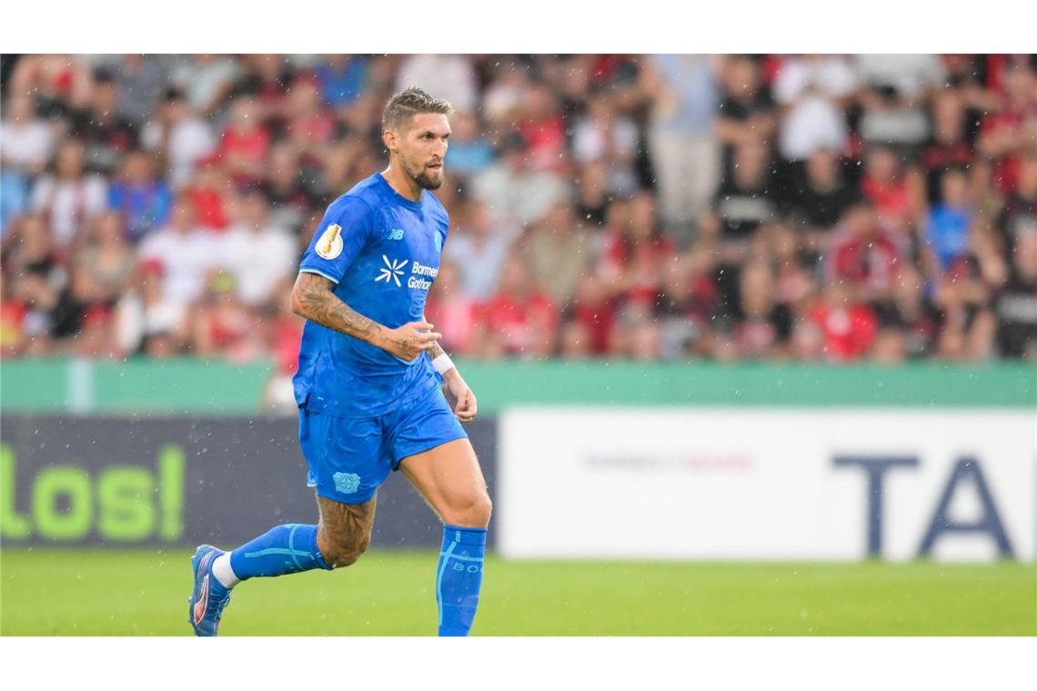 Julian Andrich von Bayer 04 Leverkusen dribbelt den Ball konzentriert, während es regnet.