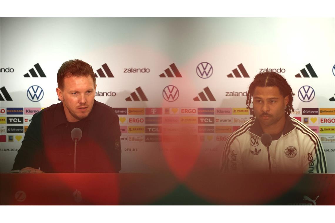 Julian Nagelsmann (l) und Serge Gnabry sprechen bei der DFB-Pressekonferenz.