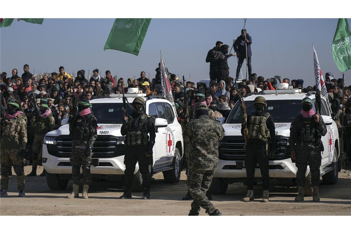 Islamisten lassen drei weitere Geiseln im Gazastreifen frei Kämpfer der Hamas und des Islamischen Dschihad beziehen Stellung vor Autos des Internationalen Roten Kreuzes, die auf die israelischen Geiseln warten.
