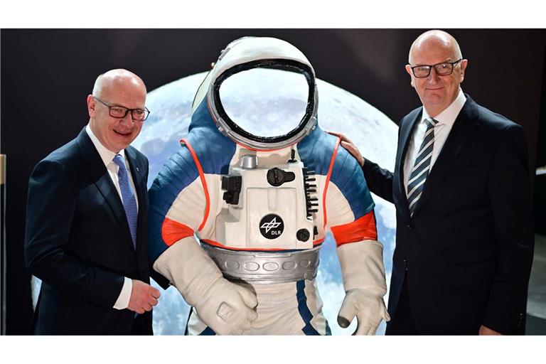 Kai Wegner (l, CDU), Regierender Bürgermeister von Berlin, und Dietmar Woidke (SPD), Ministerpräsident von Brandenburg, stehen neben einem Modell eines Weltraumanzuges.
