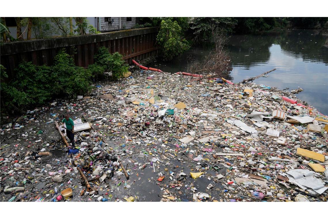 Kampf dem Müll: Ein Arbeiter sammelt Plastikmüll und andere Abfälle am San Juan-Fluss auf den Philippinen ein.