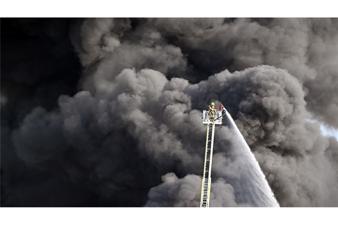 Bilder des Tages Kampf gegen das Feuer: Feuerwehrleute löschen den Brand einer Lagerhalle mit Müll in der Gemeinde Swisttal bei Bonn.