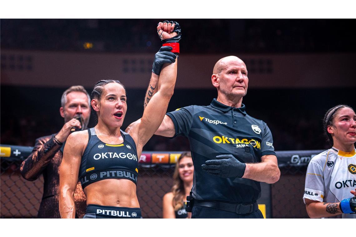 Spektakulärer Knockout – Alina Dalaslan mischt Oktagon weiter auf Kampfrichter Gerd Richter hebt den Arm der Siegerin Alina Dalaslan. Clara Ricignuolo (re.) musste sich geschlagen geben, Oktagon-Mitbegründer Ondrej Novotny (li. im Hintergrund) verkündet das Ergebnis.