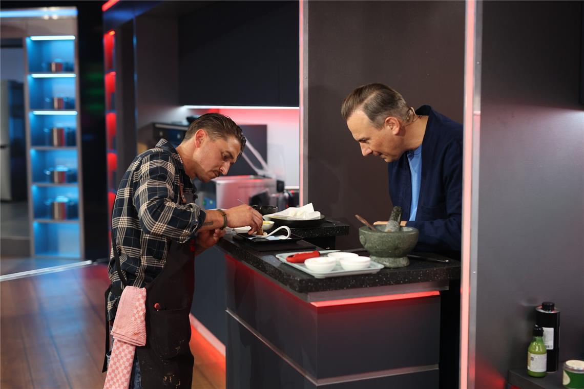 Kandidat Alfred (l.) benötigt im Entscheidungskochen Unterstützung von Coach Tim Raue.