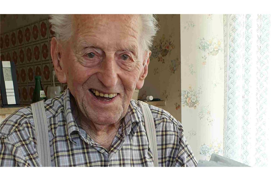 Karl Haidle sitzt an seinem 104. Geburtstag an einem Tisch und liest Zeitung.