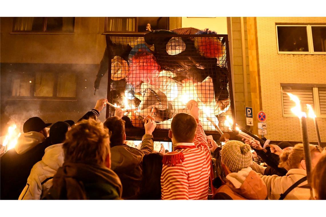 Bilder des Tages Karnevalisten in Köln zündeln ihre "Nubbel" in dem Gefängniskäfig an.