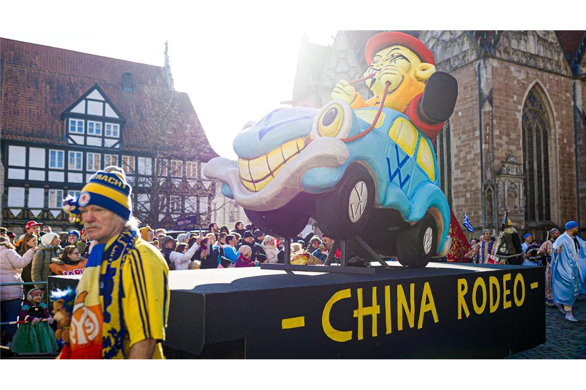 Karnevalisten nehmen mit einem Motivwagen zum Thema Volkswagen am Karnevalsumzug "Schoduvel" teil.