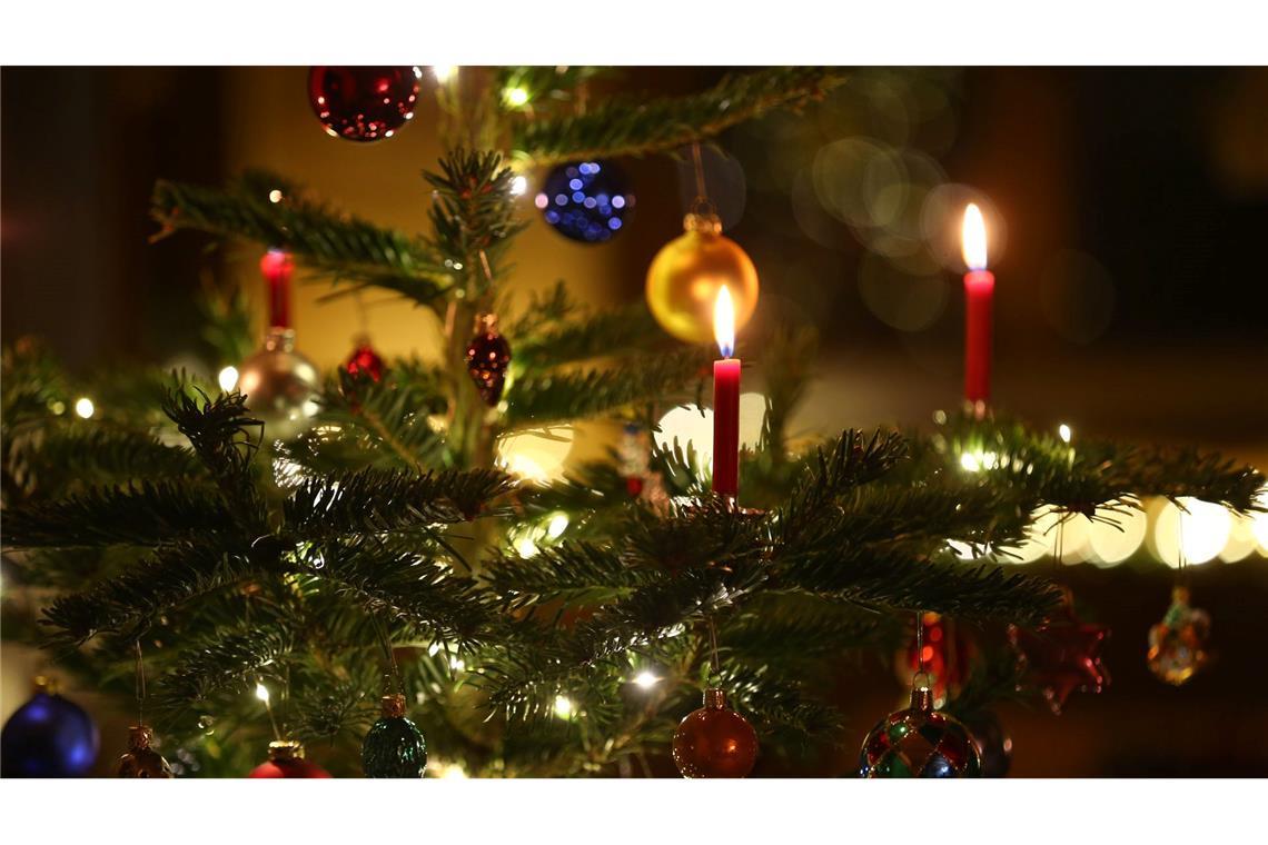 Früher war später Lametta - zeigt eine Tannenbaum-Umfrage Kerzen brennen in einem Wohnzimmer an einem geschmückten Christbaum: heutzutage oft schon zeitiger im Dezember als früher. (Symbolbild)