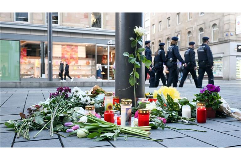 Kerzen und Blumen liegen in der Nähe des Paradeplatzes in Mannheim an einer Straßenbahnhaltestelle. (Archivfoto)