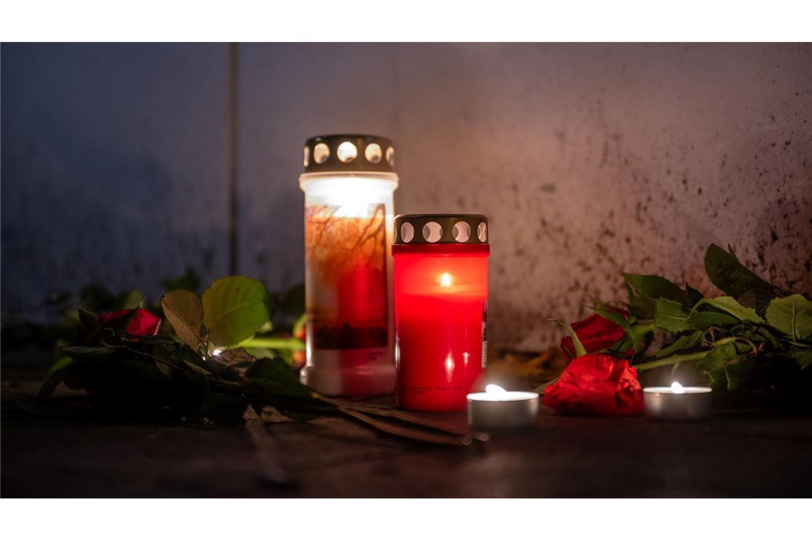 Nach Fund von drei Leichen wird mutmaßlicher Täter gesucht Kerzen vor dem Haus.