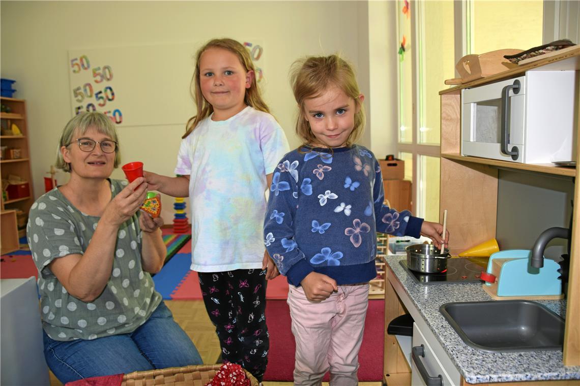 Betreuung über die Kreisgrenze hinweg Kindergartenleiterin Sabine Macheleidt (von link) assistiert Nele und Haylie am Herd der kleinen Küchenzeile. Foto: Elisabeth Klaper