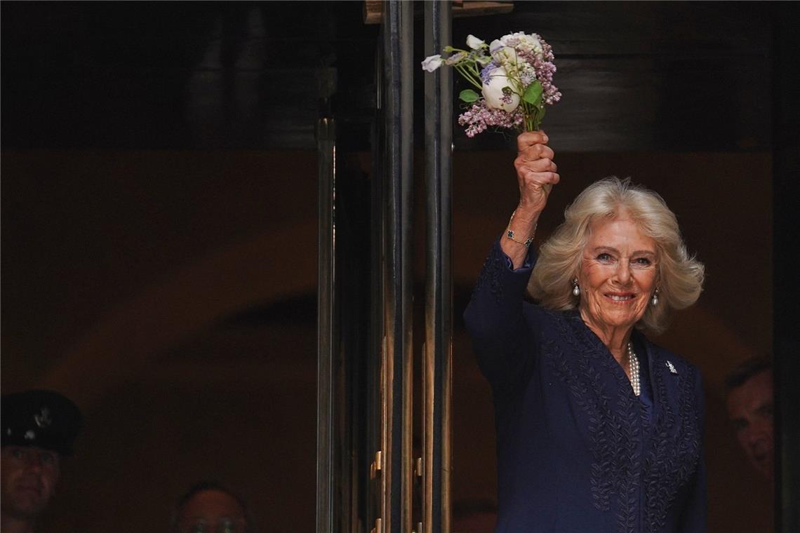 Königin Camilla winkt mit Blumen vor der New York Public Library.