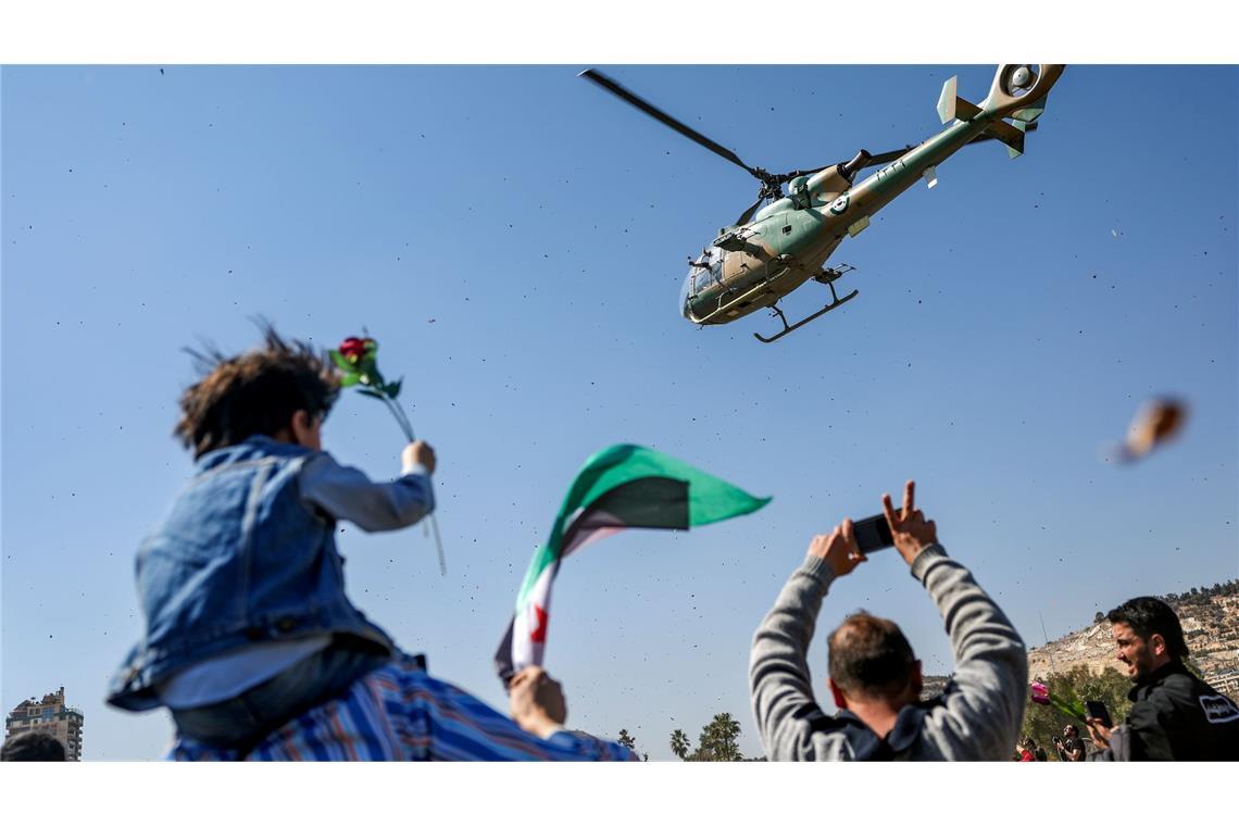 Bilder des Tages Konflikt in Syrien - Damaskus: Ein Hubschrauber der syrischen Armee wirft Blumen und Konfetti auf eine Gruppe von Demonstranten, die den 14. Jahrestag des Beginns des Aufstands gegen das Regime von Assad im März 2011 feiern, auf dem Umayyad-Platz.