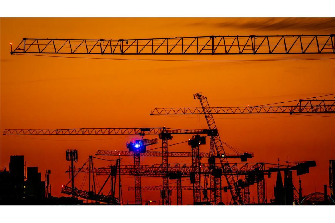 Bilder des Tages Kran-Ballett: Baukräne, die im Zentrum von München stehen, sind nach Sonnenuntergang vor dem Abendhimmel zu sehen.
