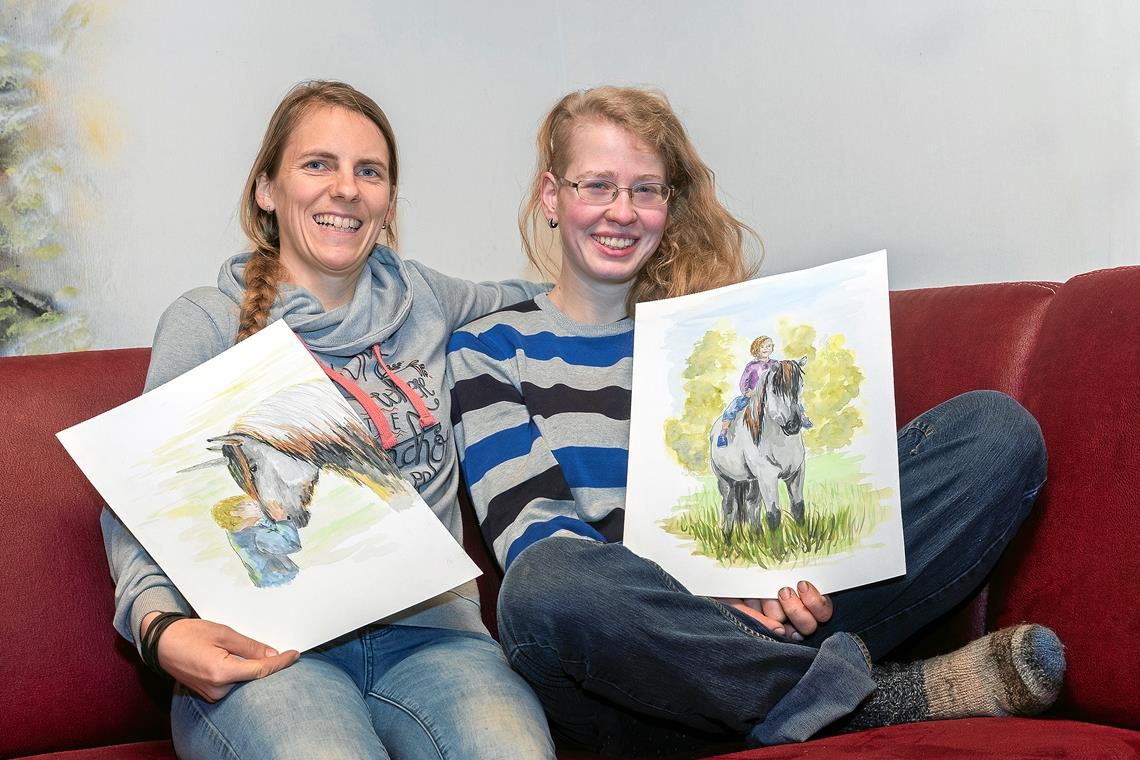Kristin Strohmaier und Magdalena Gruber (von links) zeigen bei der Lesung in Murrhardt auch einige der Originalillustrationen. Foto: J. Fiedler