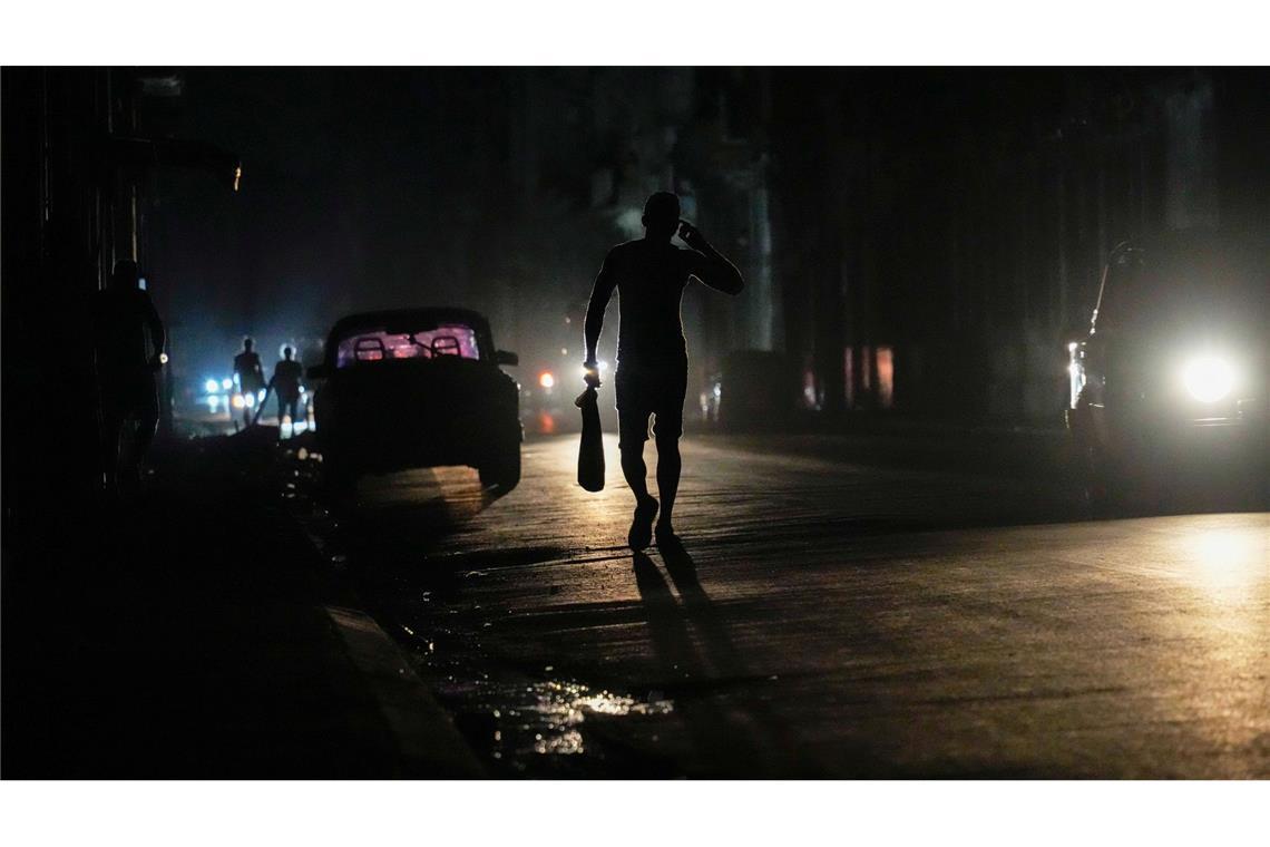 Bilder des Tages Kuba nach inselweitem Stromausfall im Dunkeln. Nach einer Störung in einem Umspannwerk behelfen sich die Menschen in Havanna mit dem Licht aus Scheinwerfern der Autos und den Displays ihrer Handys.